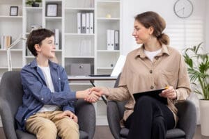 a boy shakes hands with a therapist during adolescent eating disorder treatment