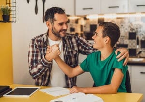 an adult and teen boy shake hands after motivational enhancement therapy