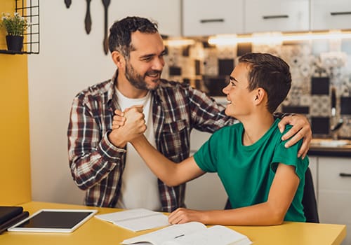 an adult and teen boy shake hands after motivational enhancement therapy